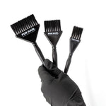 Drei schwarze PUR HAIR Färbepinsel in unterschiedlichen Größen, gehalten von einer Hand