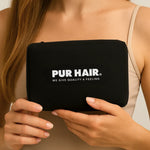 Frau hält PUR HAIR Travel Bag in schwarz mit weißem Logo in der Hand.