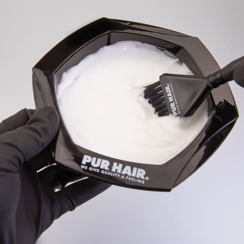 Schwarze PUR HAIR Farbschale mit weißer Blondiermasse und schwarzem Färbepinsel beim Anmischen