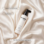 PUR HAIR Silk Therapy Anti-Frizz-Spray mit veganer Formulierung für alle Haartypen auf hellem Satin.