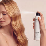 PUR HAIR Ultimate Gloss Glanzspray wird auf langes, glänzendes Haar aufgesprüht.