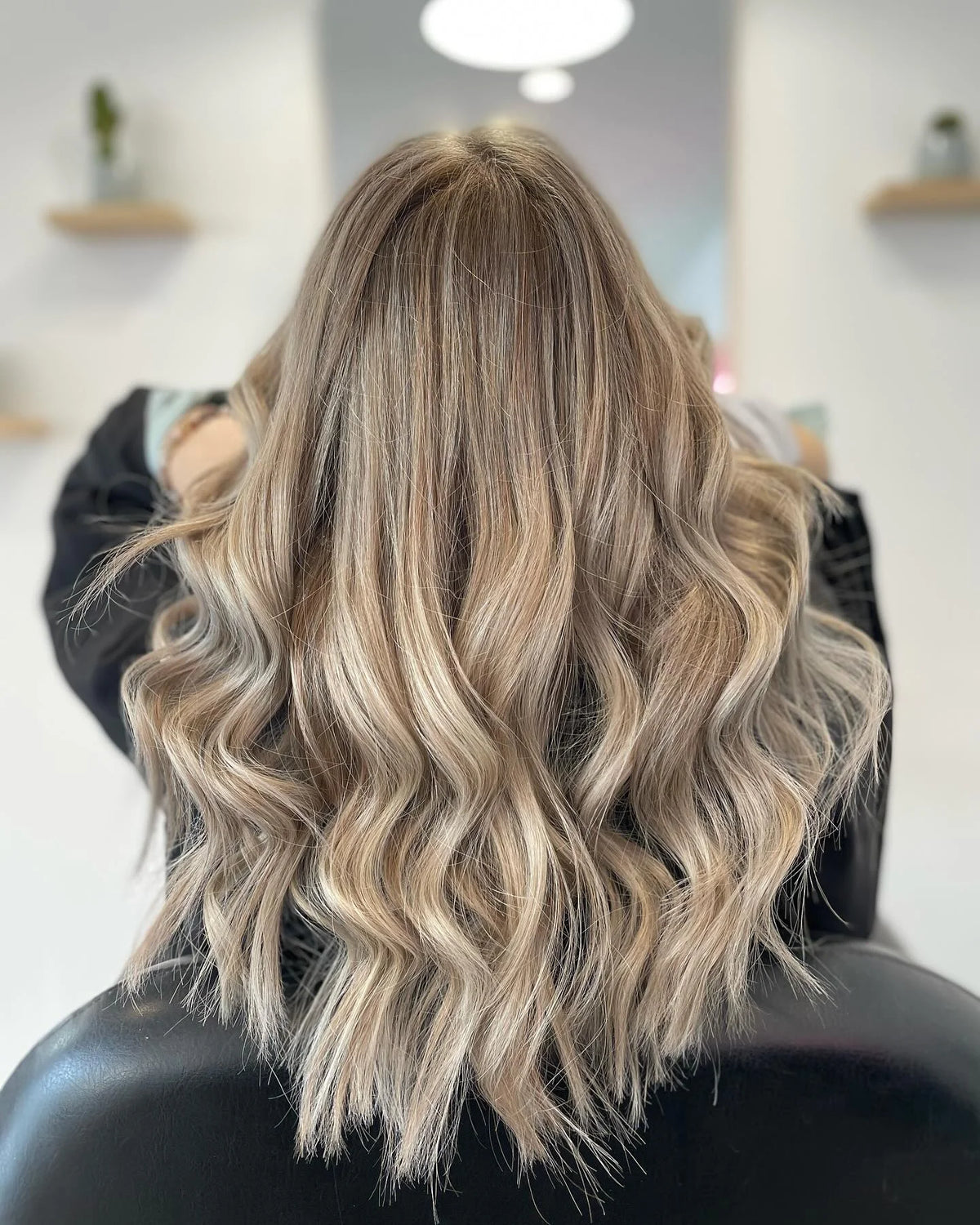 Kühles Blond mit multidimensionalen Highlights und weichen Wellen nach professioneller Coloration.