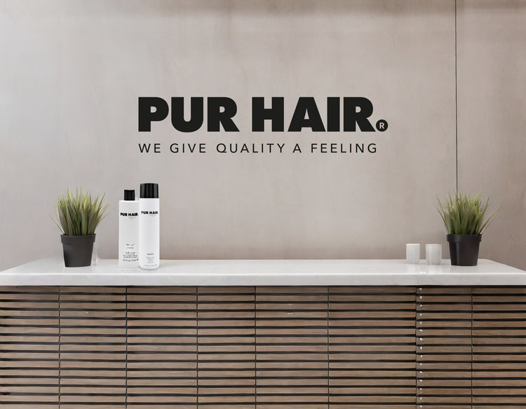 PUR HAIR Empfangsbereich mit Logo, Haarpflegeprodukten und moderner Saloneinrichtung.