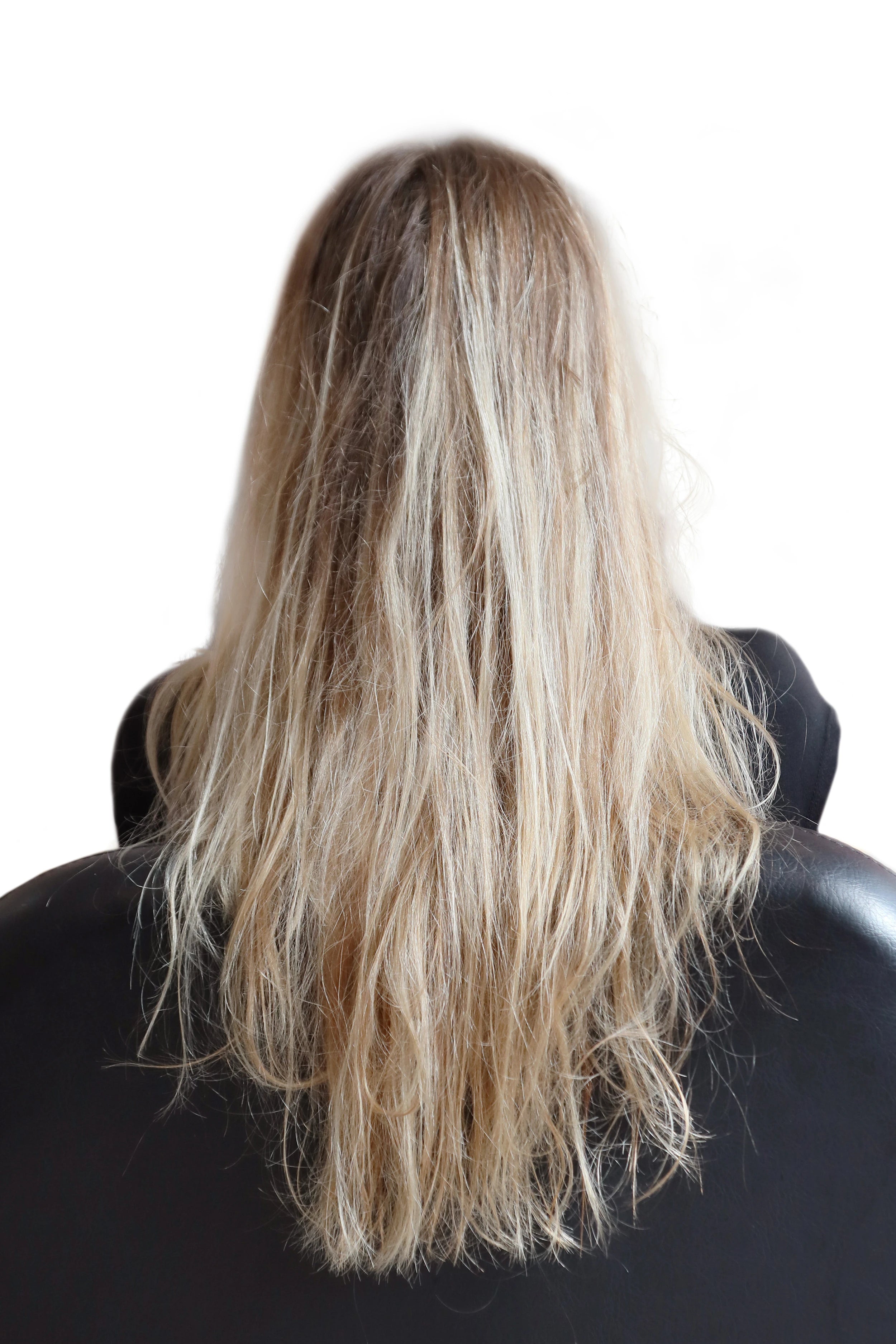 Langes blondiertes Haar vor einer professionellen Keratin-Haarglättung mit trockener, unruhiger Haarstruktur.