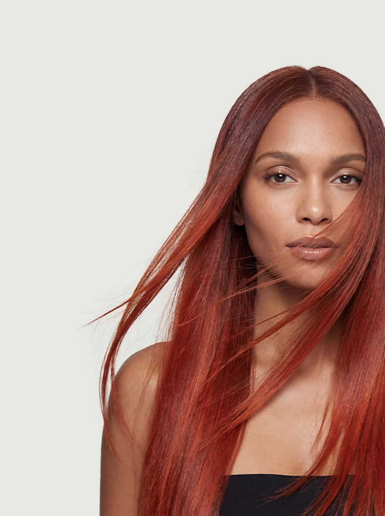 Model mit langem, intensiv kupferrotem und glänzend glattem Haar im professionellen Beauty-Shooting