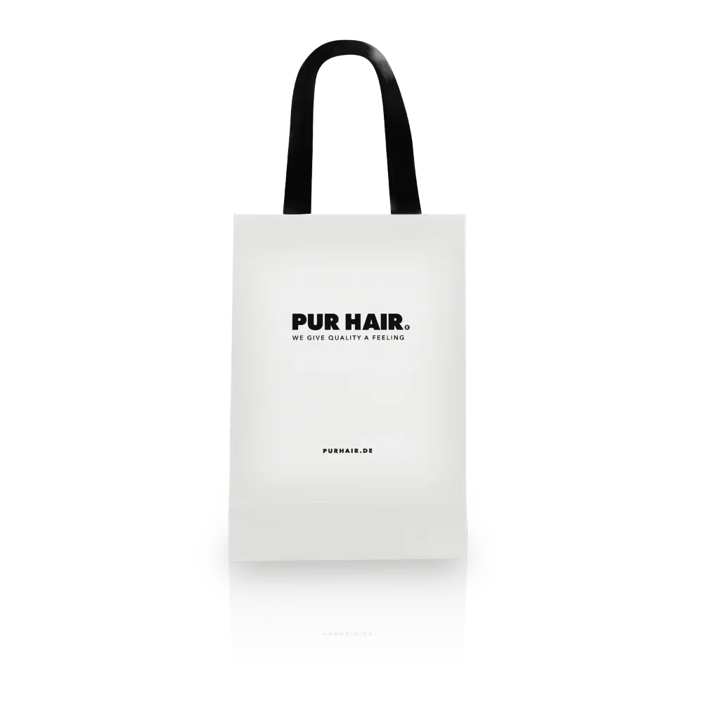 Weiße PUR HAIR Geschenktasche mit schwarzen Stoff-Tragebändern und schwarzem Logo.
