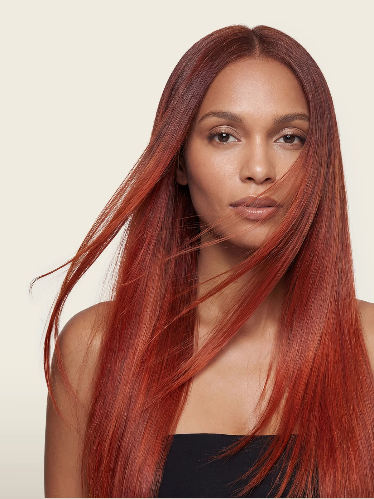 Model mit langem, intensiv kupferrotem und glänzend glattem Haar im professionellen Beauty-Shooting.
