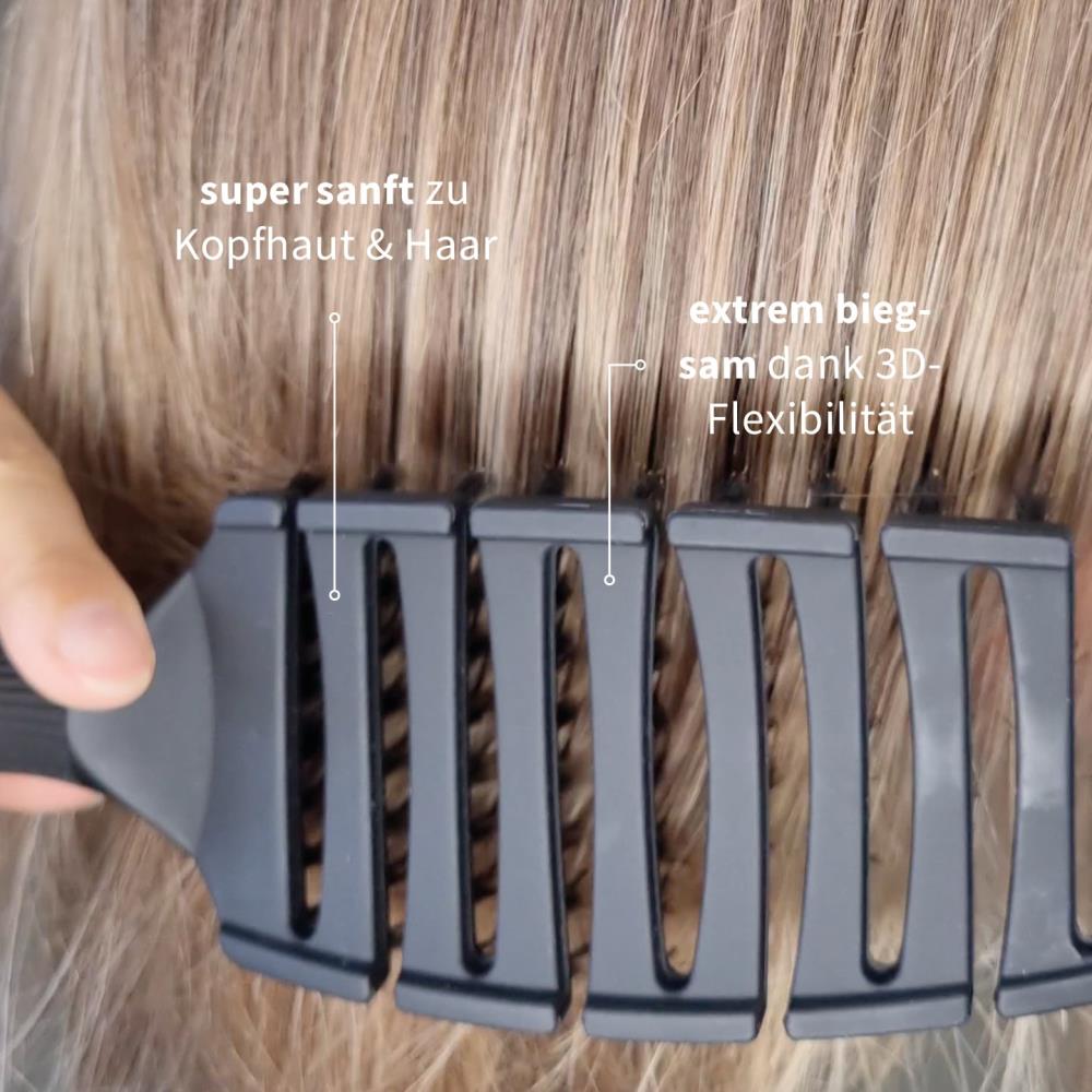Nahaufnahme einer schwarzen PUR HAIR Magic Flex Brush, die durch blondes Haar gleitet.