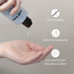 Hand drückt weißes Shampoo aus PUR HAIR Magic Keratin Flasche