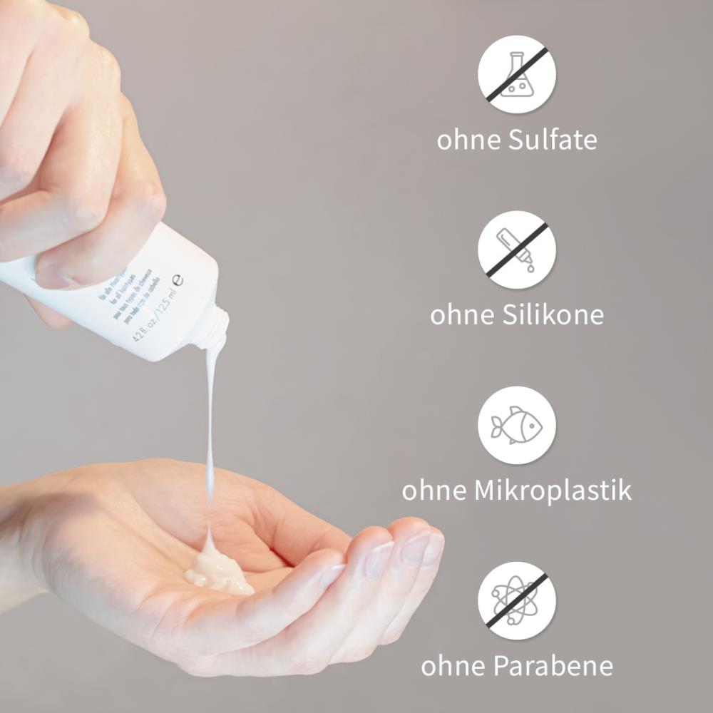 Hand drückt weißes Moisture Treatment aus der Tube in die Handfläche.