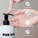 Finger pumpt weißes Shampoo aus PUR HAIR Organic Flasche.