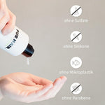 Hand drückt weißes Shampoo aus PUR HAIR Organic Flasche.
