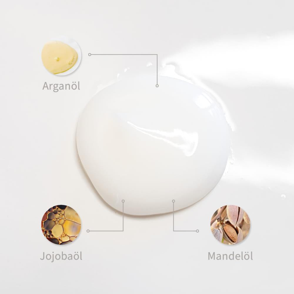 Weiße Creme-Textur mit markierten Inhaltsstoffen: Arganöl, Jojobaöl und Mandelöl.