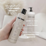Hand hält PUR HAIR Magic Gum Repair Mask & Conditioner.