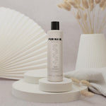 PUR HAIR Magic Gum Repair Shampoo 250 ml steht vor dekorativen Wand