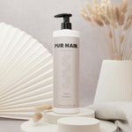 PUR HAIR Magic Gum Repair Shampoo 1000 ml steht vor dekorativem Hintergund