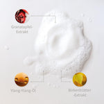 Weiße Schaum-Textur mit markierten Inhaltsstoffen: Granatapfel-Extrakt, Ylang-Yang-Öl, Birkenblätter